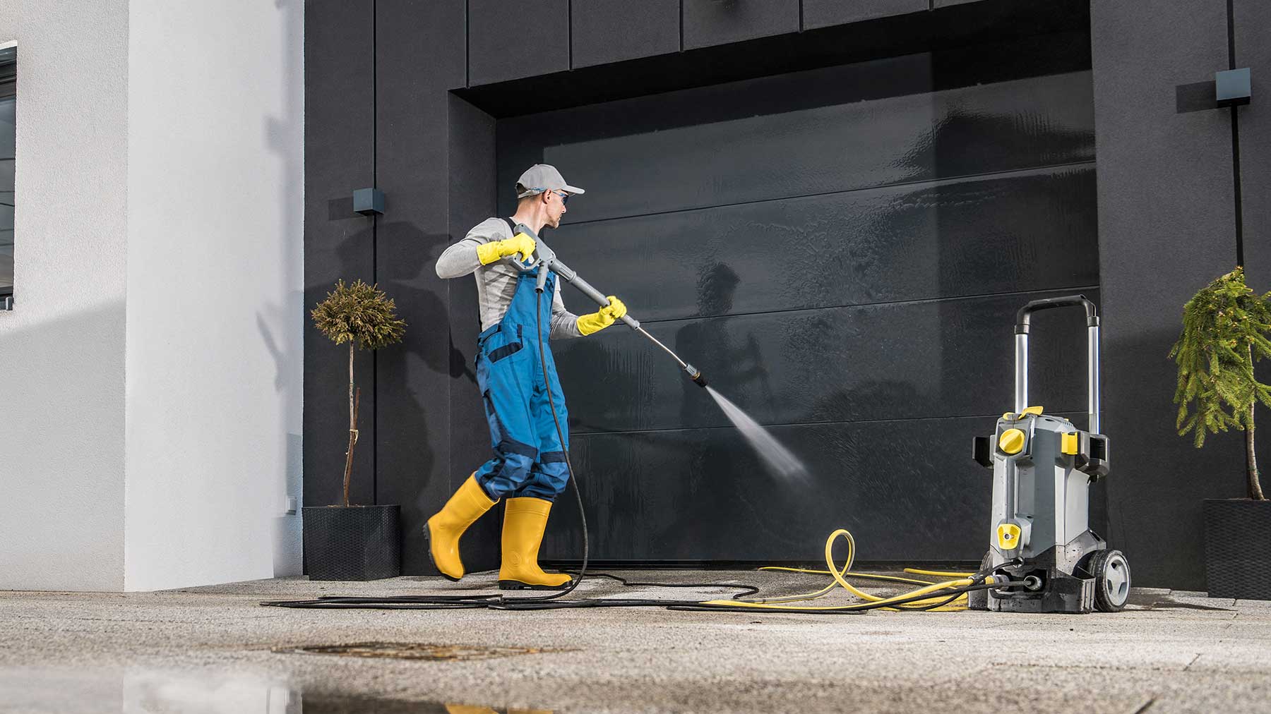 Mann reinigt Garage mit Hochdruckreiniger